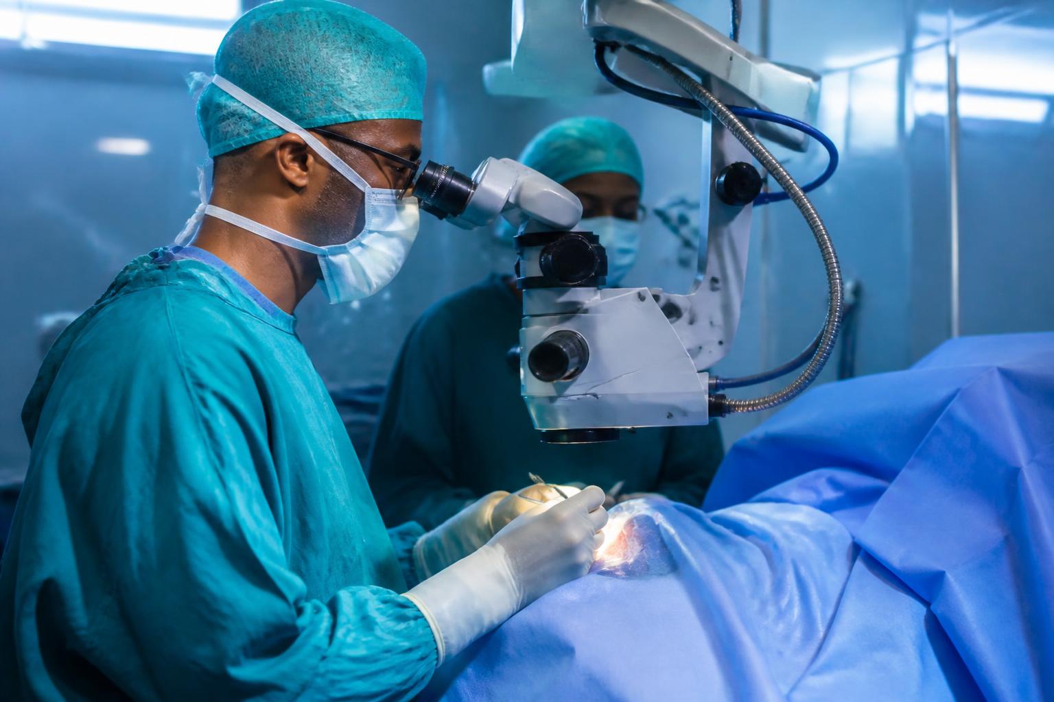 Eye surgeon operating using an operating microscope in a modern theatre